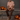 Male model sitting on a metal table surrounded by Jack'O Lanterns. Wearing Da Vinci's Decades Shirt and a pair of slim brown pants and olive slippers. 